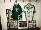 deux maillots accrochés au mur à côté d'une photo