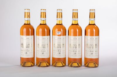 quatre bouteilles de vin sont alignées sur une surface blanche