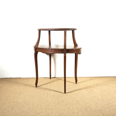 une petite table en bois avec un plateau en marbre, posée sur un sol recouvert de moquette