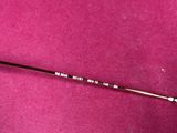 a close up of a golf club on a pink surface
