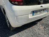 a small white car parked on the side of the road