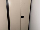 a white cabinet with a black door in a room