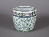 un vase blanc orné de motifs verts et roses