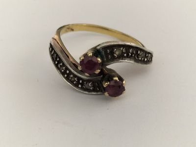 a close up of a ring with two stones on a white surface