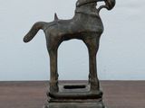 a statue of a horse that is on a wooden table