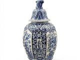 a blue and white vase with a bird on top of it