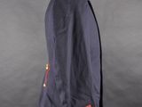the back of a blue jacket with red buttons on a mannequin stand