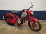 a red motorcycle parked in a garage with a blue wall