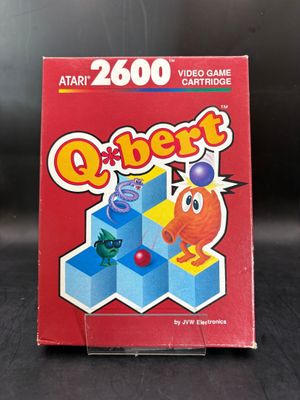 La boîte du jeu vidéo Q-Bert est posée sur la table.
