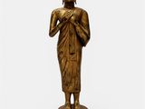 a bronze statue of a buddha standing on a pedestal