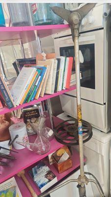 une étagère rose sur laquelle se trouvent des livres et un balai