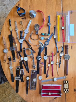 une table sur laquelle sont posées de nombreuses montres et d'autres objets