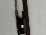 a violin bow and a violin stick on a white surface