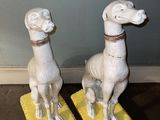 deux statues d'animaux assis sur un tapis jaune