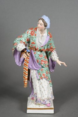 an antique figurine of a woman in a kimono dress