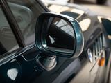 a side view mirror of a car on the side of the road