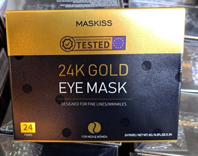 un coffret contenant un masque pour les yeux en or 24 carats posé sur une table