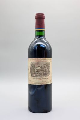 une vieille bouteille de vin posée sur une table blanche