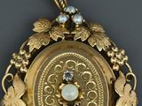 a picture of a gold locke with pearls and leaves on it