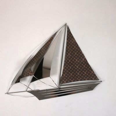 un miroir accroché au mur sur lequel est représenté un voilier