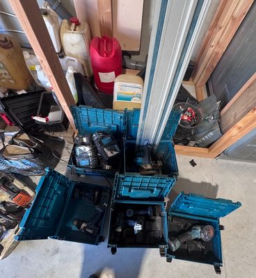 un homme debout à côté d'un tas d'outils dans un garage