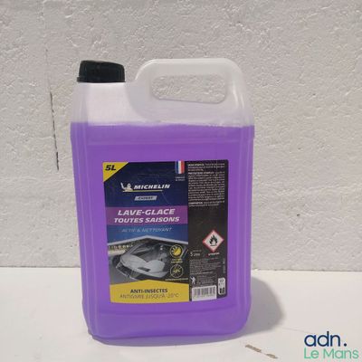 un gros plan sur une bouteille contenant un liquide violet posée sur une table