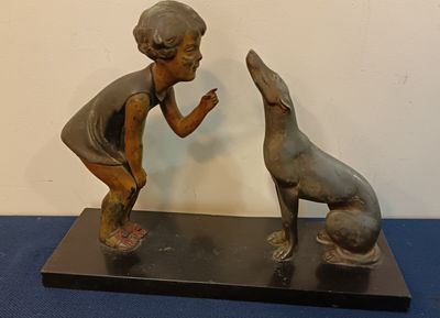 Groupe en régule figurant un enfant et son chien, sur une te…