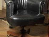 a black leather office chair sitting on a wooden floor