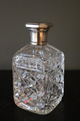 a small glass bottle with a silver lid on a table