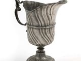 an old silver vase with a handle on a stand