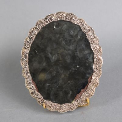 an image of a picture of a black stone in a gold plated frame