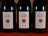 four bottles of wine are lined up on a table