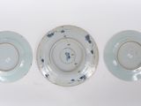 three blue and white plates are sitting next to each other