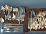 beaucoup d'argenterie sur une table recouverte d'une nappe marron