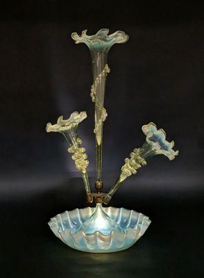 une photo représentant un vase en verre contenant des fleurs, posé sur une table