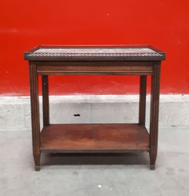 une table en bois surmontée d'une étagère, placée devant un mur rouge