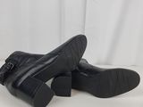 a pair of black leather boots with buckles on the toes