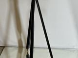 an old camera on a tripod stand on a glass table