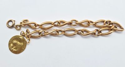 a close up of a gold chain bracelet with a coin on it