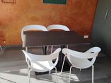 a table and chairs in a room with orange walls