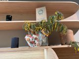 a vase with yellow flowers on a shelf in a room