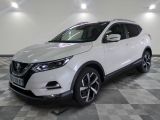 the white nissan suv is parked on a checkered floor