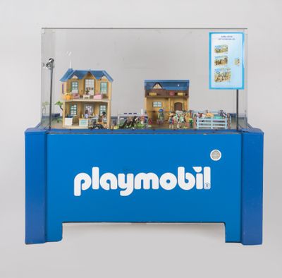 une vitrine Playmobil bleue contenant une maison de poupées