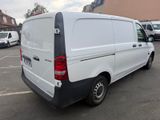 the back end of a white van parked in a parking lot