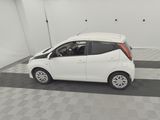 a picture of a small white car parked in a garage