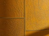 a toilet in a bathroom with a yellow wall behind it