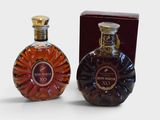 two bottles of brandy sitting next to each other on a white surface