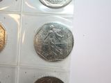 six different types of silver and gold coins on a white surface