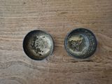 two tins that are sitting on a wooden table