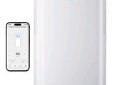 a white air conditioner sitting next to a smart phone